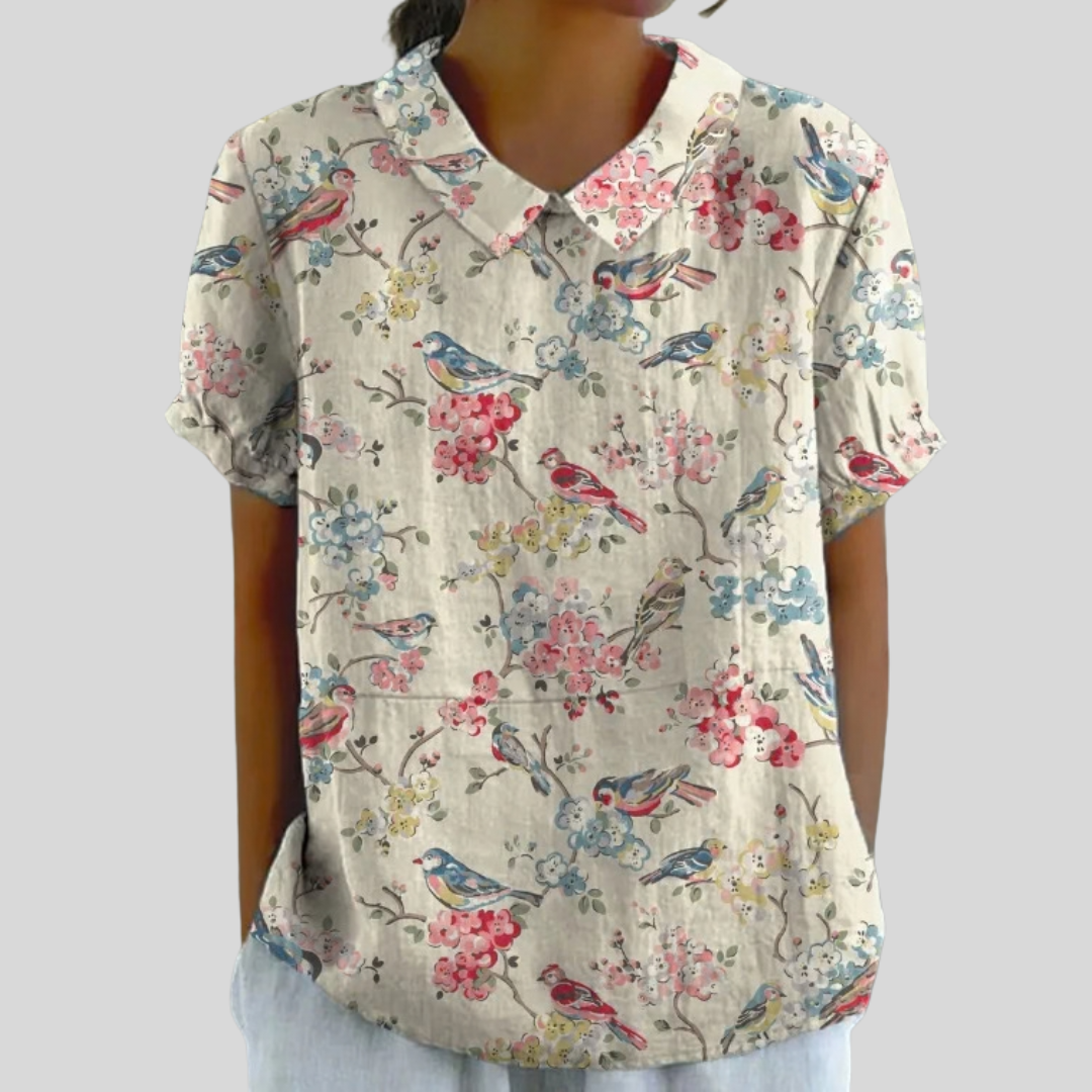 A woman wearing a soft floral top with a neat polo collar, looking effortlessly feminine.