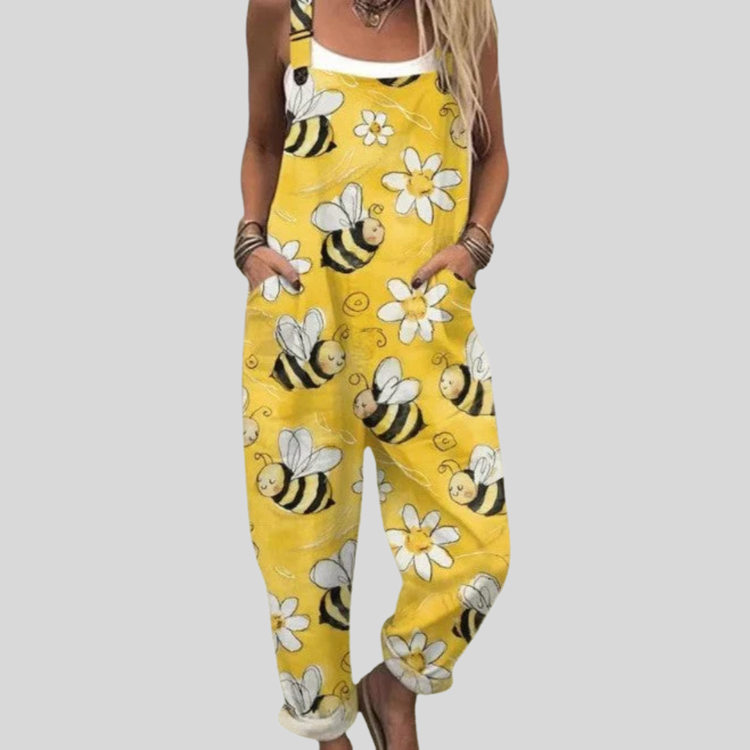 Women's relaxed dungarees in bright yellow with a cheerful bee and white daisy print across the fabric.