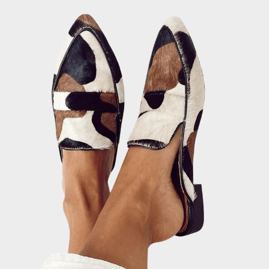 A woman wearing refined loafers with a smart, elegant outfit