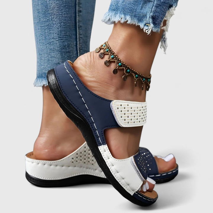 A woman walking confidently in wide-fit comfort sandals with a cushioned, supportive footbed.
