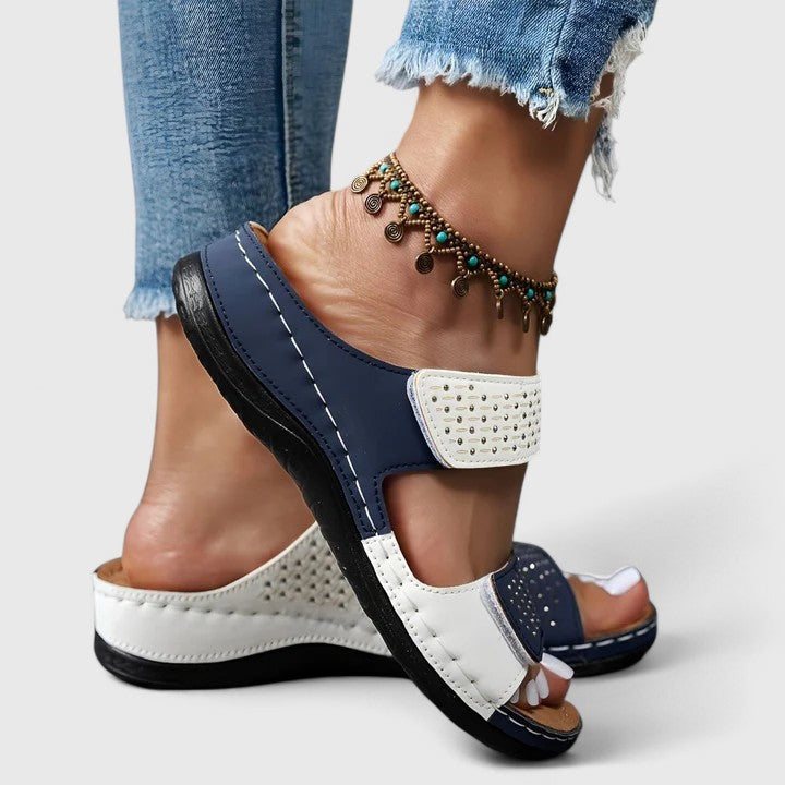 A woman walking comfortably in open-toe wide-fit orthopaedic sandals with a cushioned footbed.