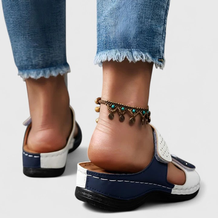 A woman walking comfortably in open-toe wide-fit orthopaedic sandals with a cushioned footbed.