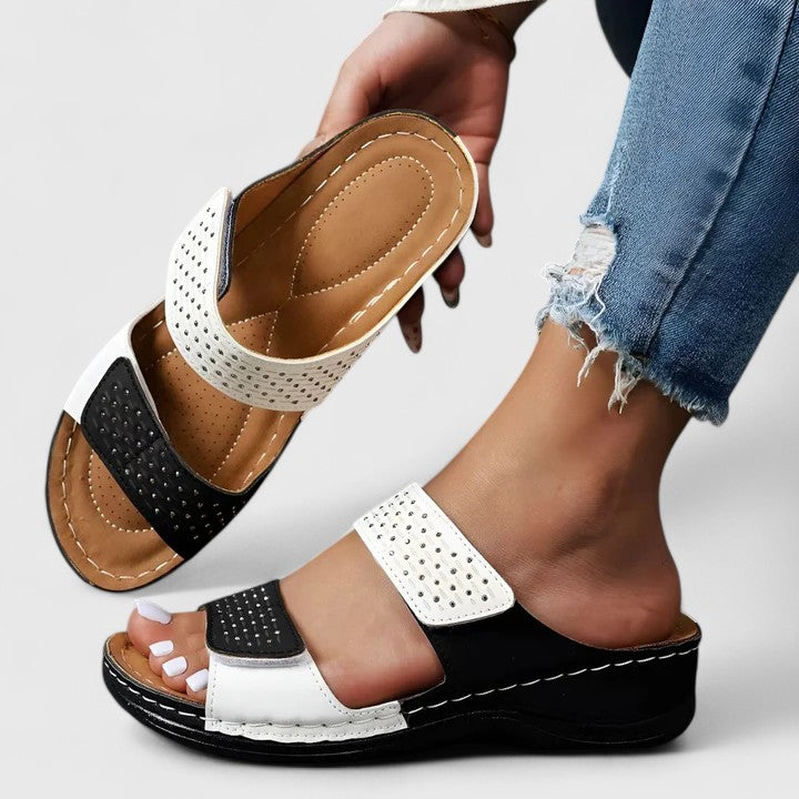 A woman walking comfortably in open-toe wide-fit orthopaedic sandals with a cushioned footbed.