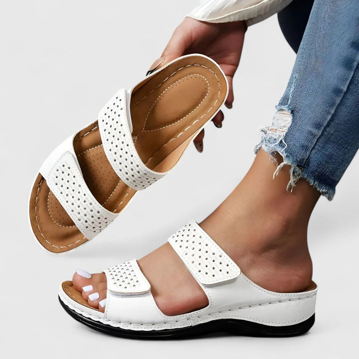 A woman walking confidently in wide-fit comfort sandals with a cushioned, supportive footbed.