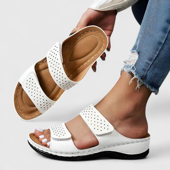 A woman walking comfortably in open-toe wide-fit orthopaedic sandals with a cushioned footbed.