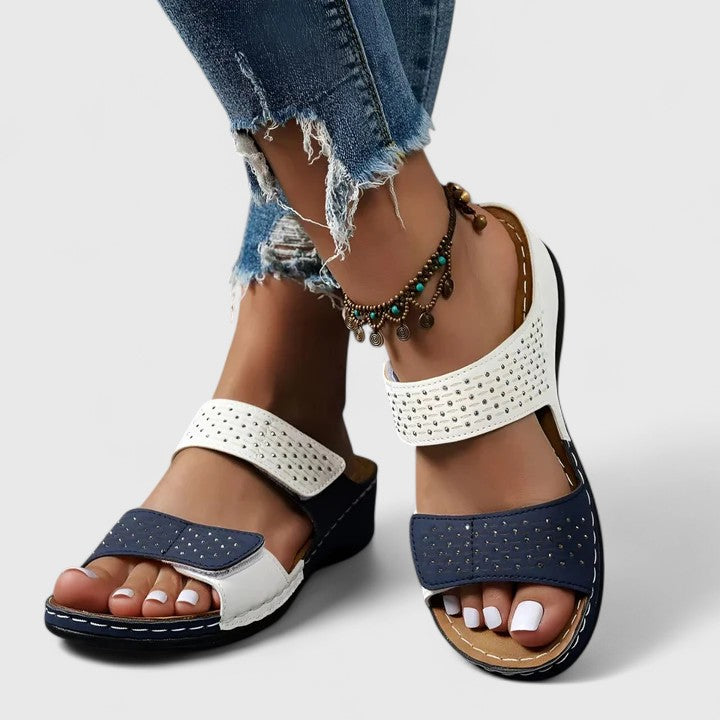 A woman walking comfortably in open-toe wide-fit orthopaedic sandals with a cushioned footbed.