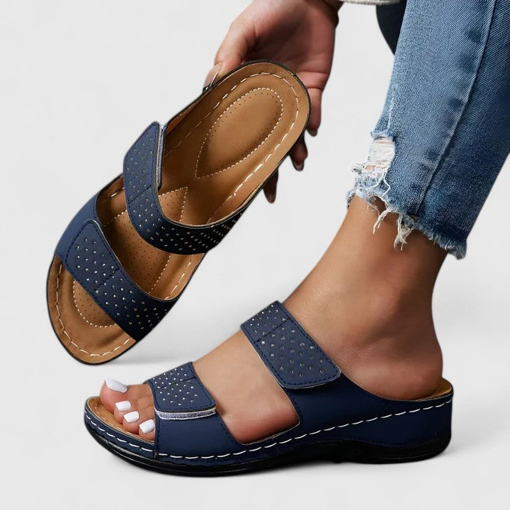 A woman walking comfortably in open-toe wide-fit orthopaedic sandals with a cushioned footbed.