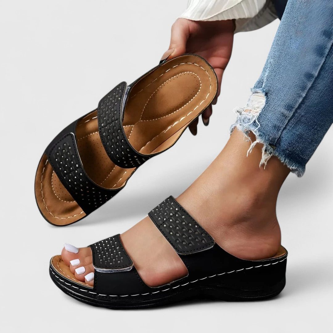 A woman walking confidently in wide-fit comfort sandals with a cushioned, supportive footbed.