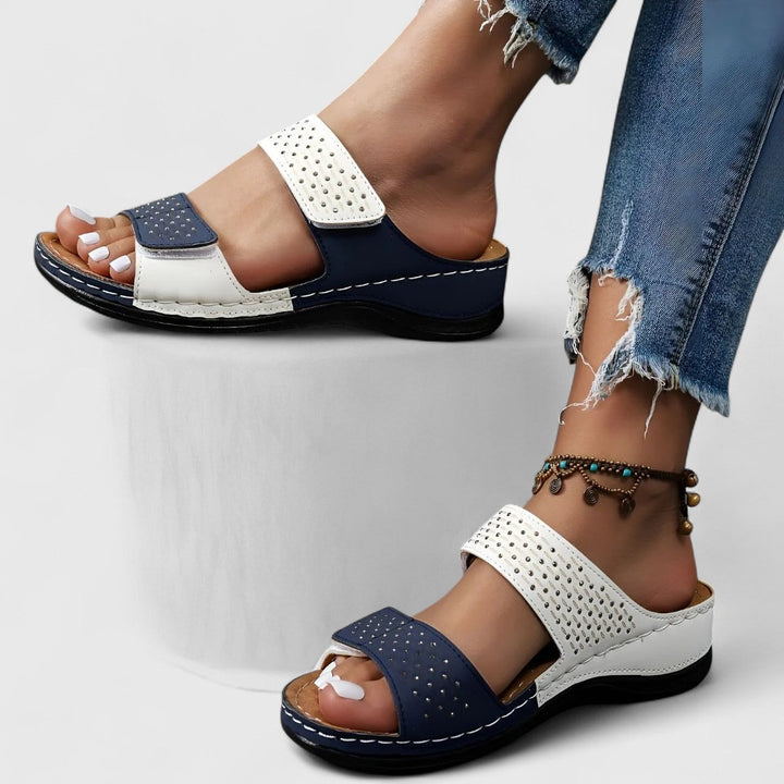 A woman walking confidently in wide-fit comfort sandals with a cushioned, supportive footbed.