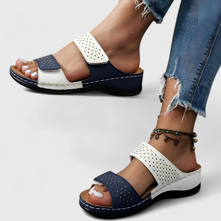 A woman walking comfortably in open-toe wide-fit orthopaedic sandals with a cushioned footbed.
