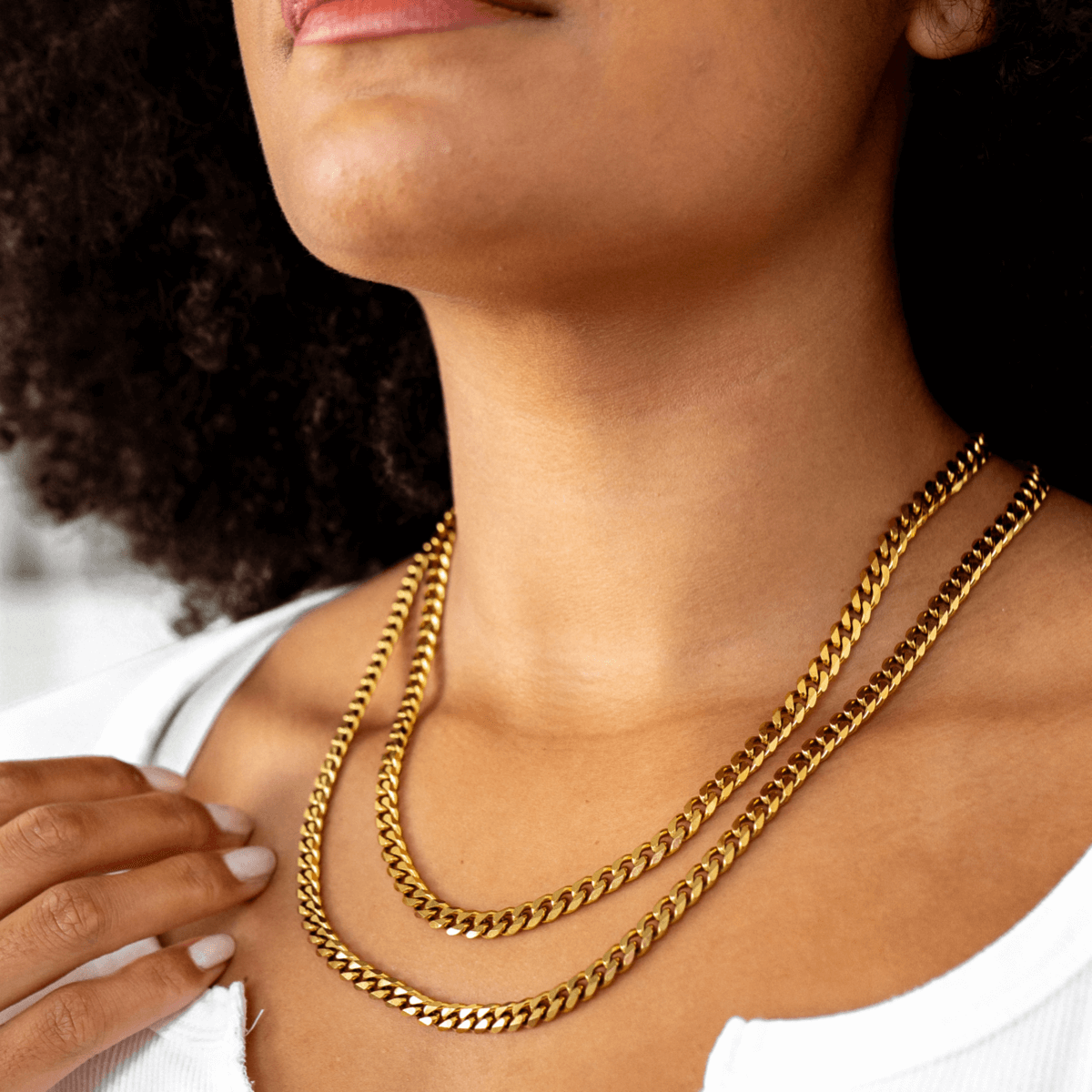 Gold Cuban-style pendant necklace on a white background