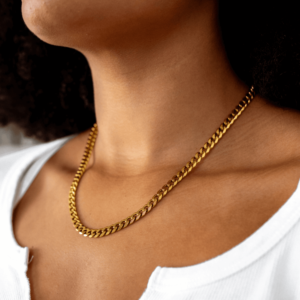 Gold Cuban-style pendant necklace on a white background