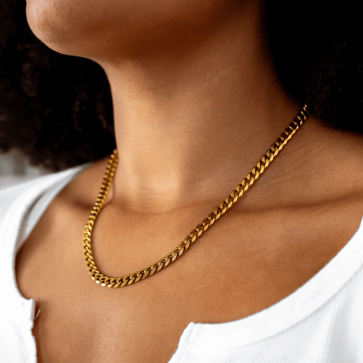 Gold Cuban-style pendant necklace on a white background