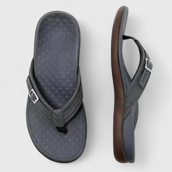 A woman in light blue lightweight flip-flops relaxing on a sunny terrace, feet light and comfortable.