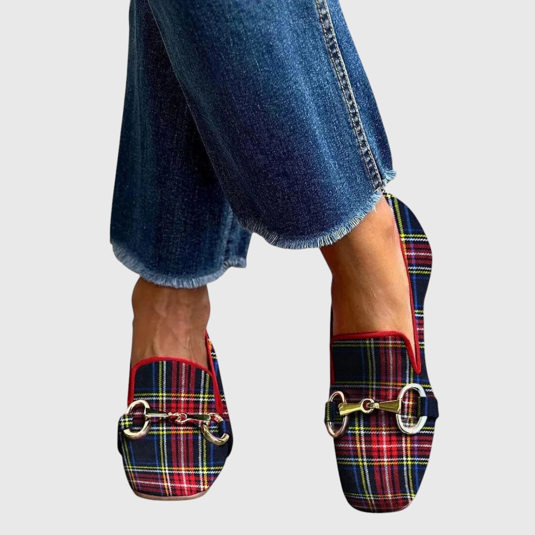 A woman wearing checked loafers with a smart, pulled-together outfit