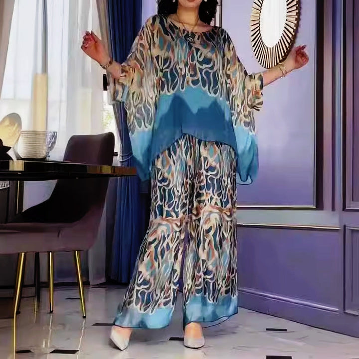 A woman wearing a flowing abstract-print two-piece set with wide-leg trousers