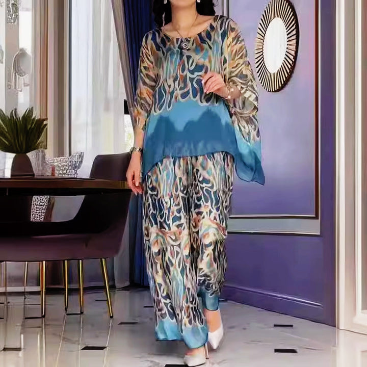 A woman wearing a flowing abstract-print two-piece set with wide-leg trousers
