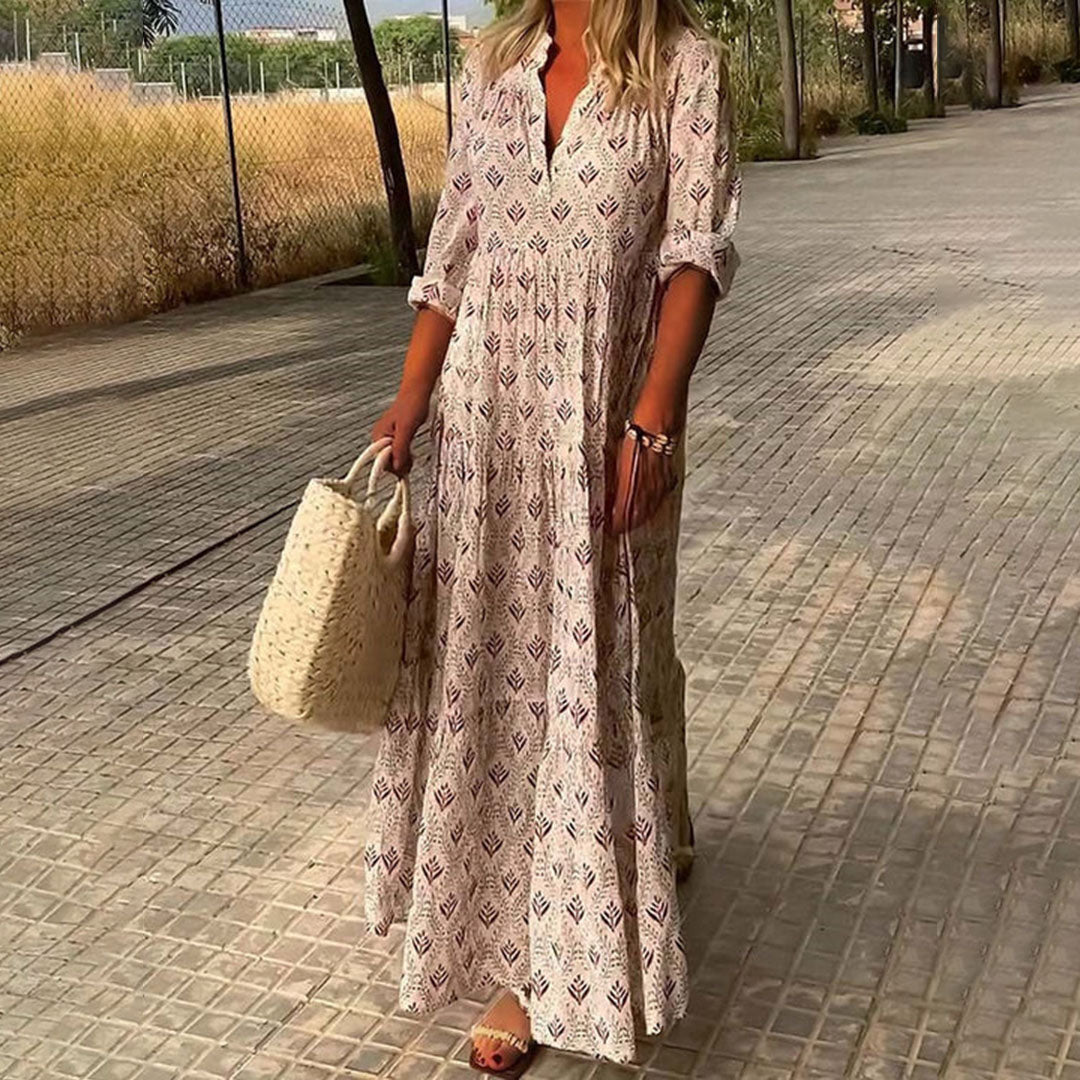 Woman wearing the Imelda™ elegant boho maxi dress with a V-neckline and flowing skirt at a summer occasion.