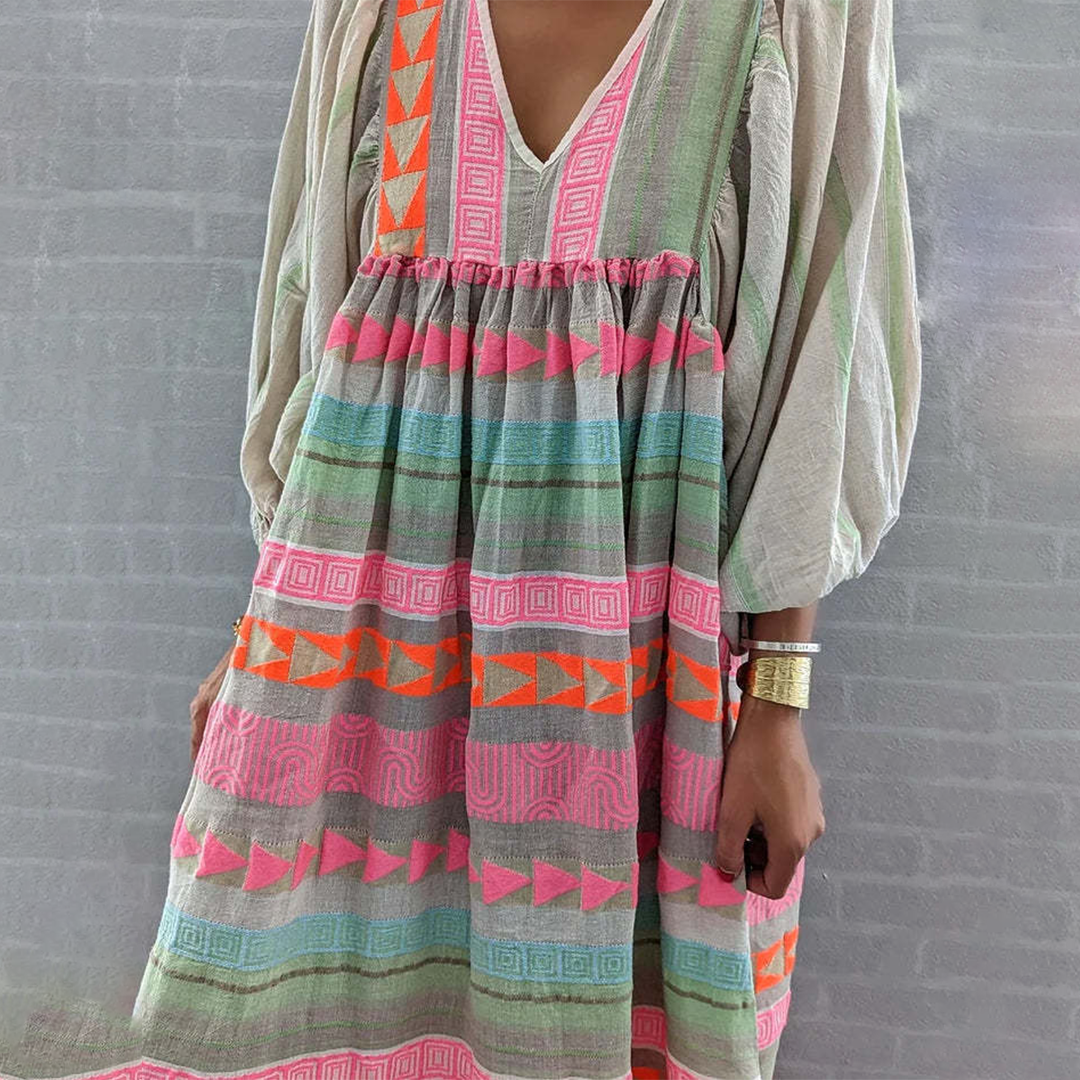 Woman wearing the Noreen™ colourful geometric print boho dress with puffed sleeves, out enjoying a casual day.