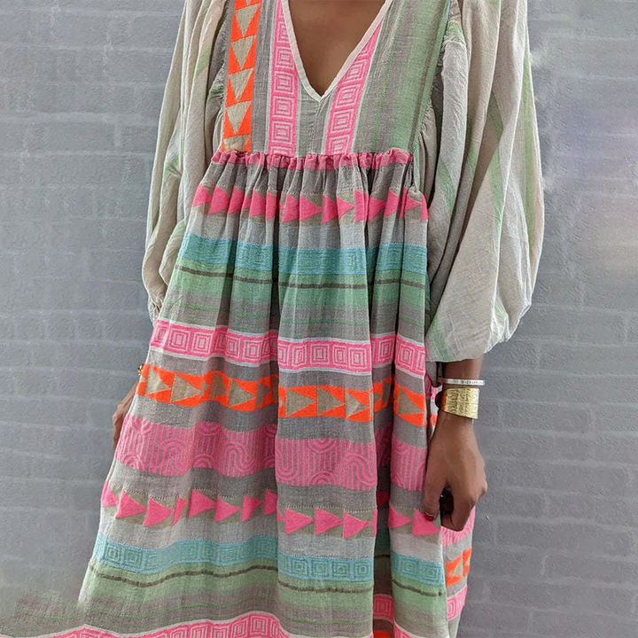Woman wearing the Noreen™ colourful geometric print boho dress with puffed sleeves, out enjoying a casual day.
