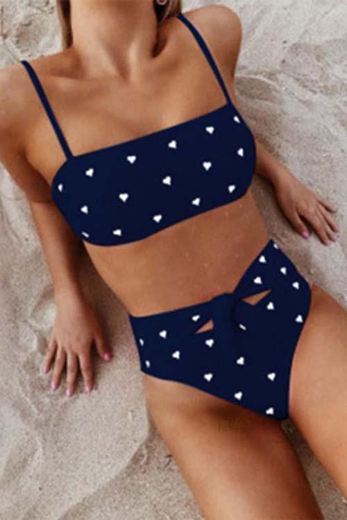 Pink high-waist bikini with a heart print pattern and an adjustable bow on the bottoms