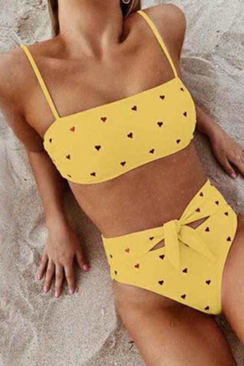 Pink high-waist bikini with a heart print pattern and an adjustable bow on the bottoms