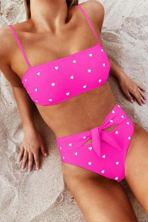 Pink high-waist bikini with a heart print pattern and an adjustable bow on the bottoms
