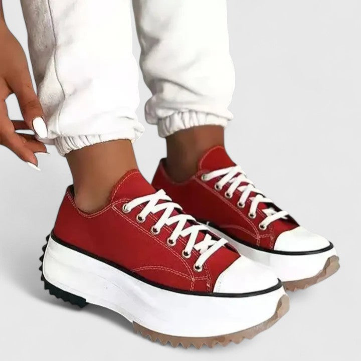 A woman in bold lace-up platform comfort trainers styled with jeans.