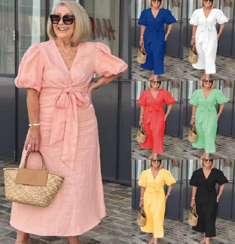 Woman wearing the Bridget bow-front midi dress with puff sleeves at a garden party.