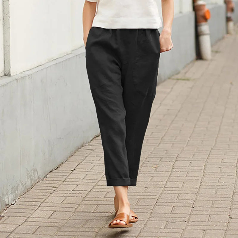 A woman wearing wide relaxed trousers with two roomy pockets and an elastic waist.