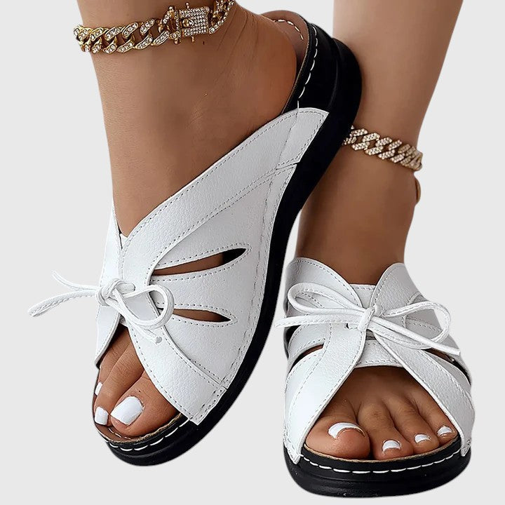 A woman in blue slip-on band sandals stepping out easily, feet cushioned and comfortable.