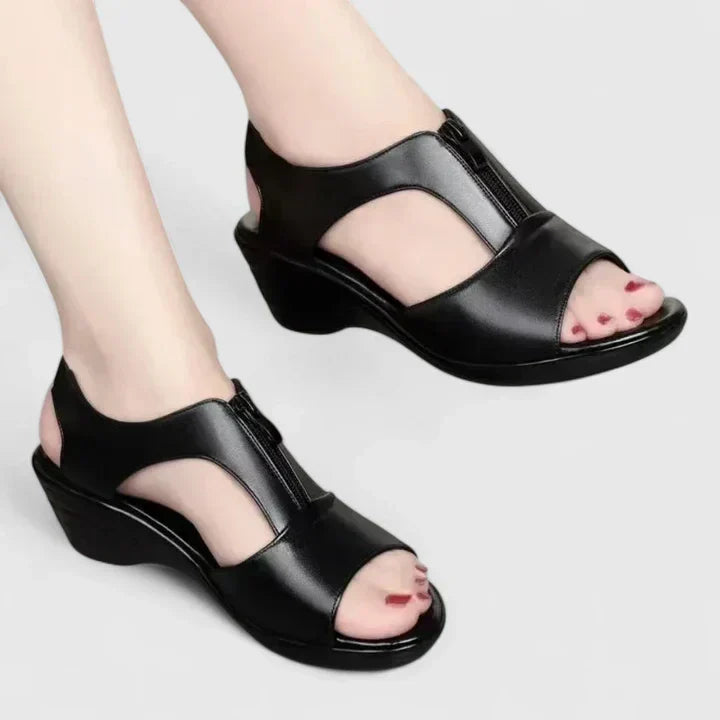 Black peep-toe sandals with a buckled instep strap and a sturdy block heel.