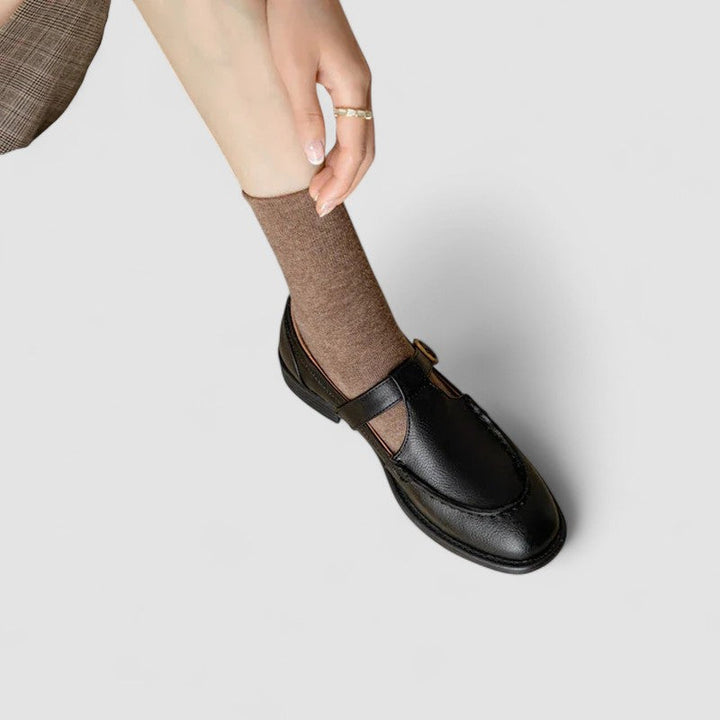A woman in black round-toe Mary Jane shoes, comfortable and classic at the office.