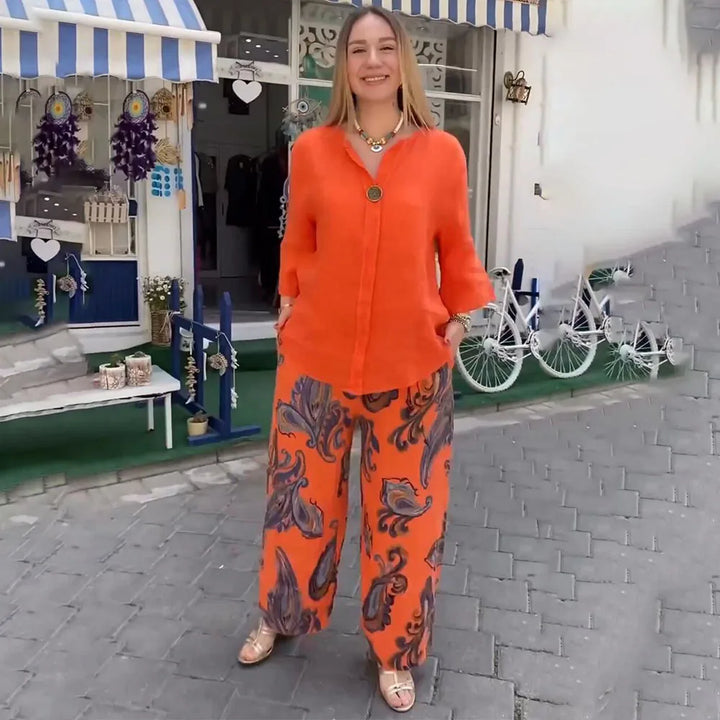 A woman wearing a bright blue blouse with matching patterned wide-leg trousers