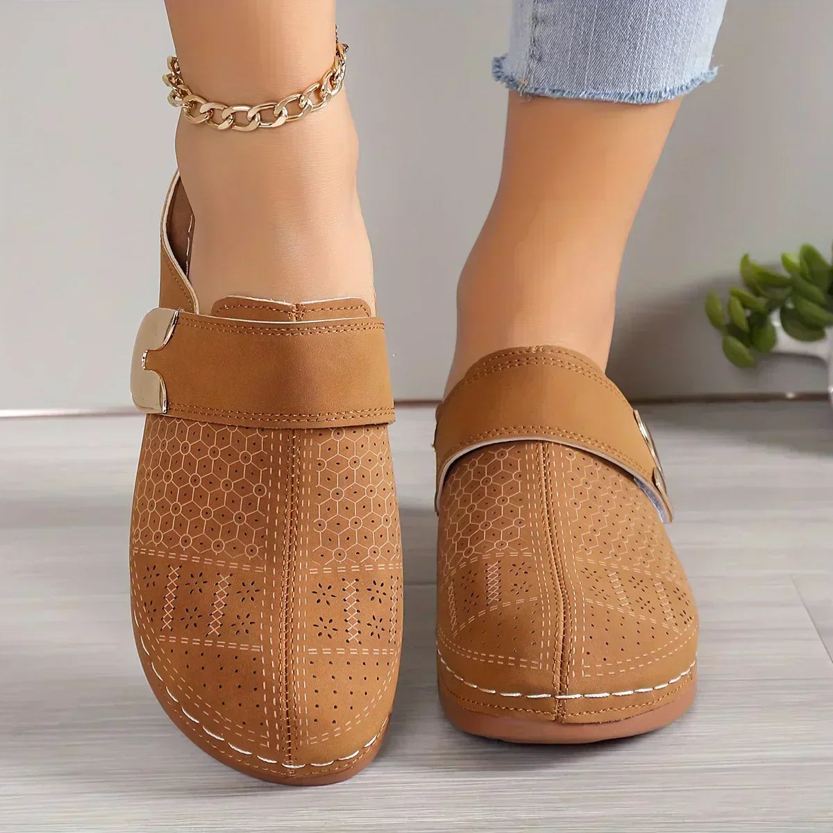 Black closed-toe clogs with decorative buckle detail