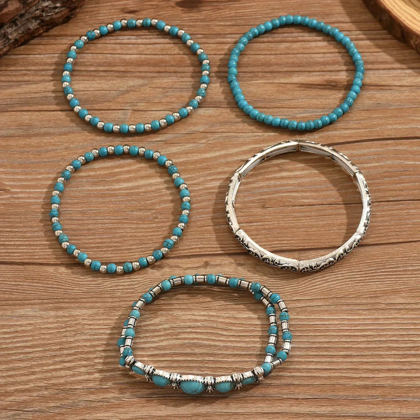 Set of turquoise and metallic boho-style stacking bracelets on a white background