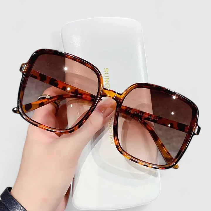 A woman running errands in town wearing classic square sunglasses, calm and stylish.