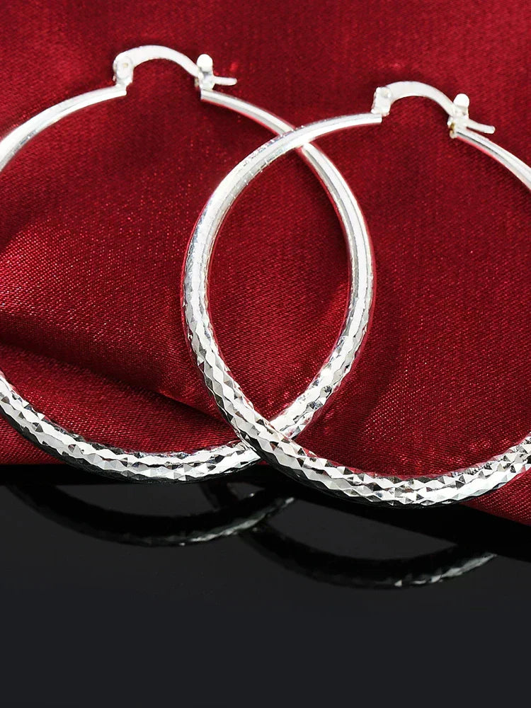 A pair of polished 925 sterling silver circular hoop earrings with a high-shine finish
