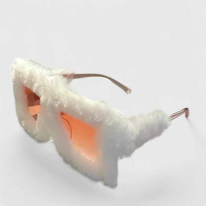 A woman on a bright winter walk wearing lightweight stylish sunglasses, smiling easily.