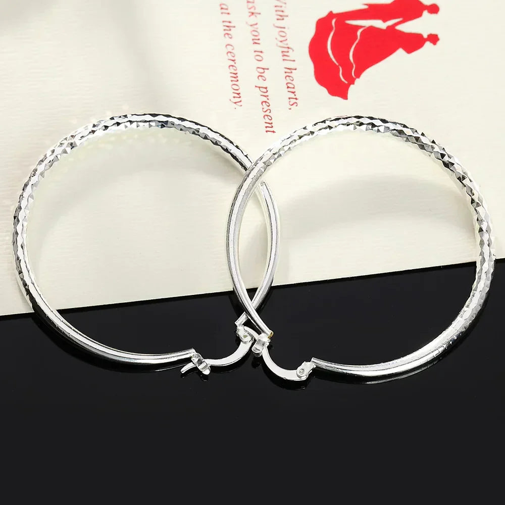 A pair of polished 925 sterling silver circular hoop earrings with a high-shine finish