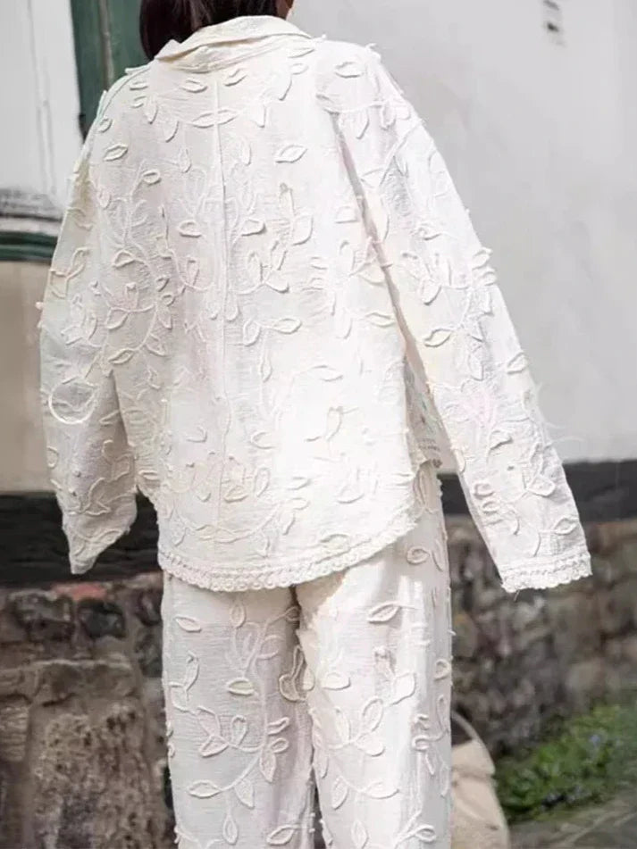 A woman wearing an embroidered relaxed two-piece set with wide trousers