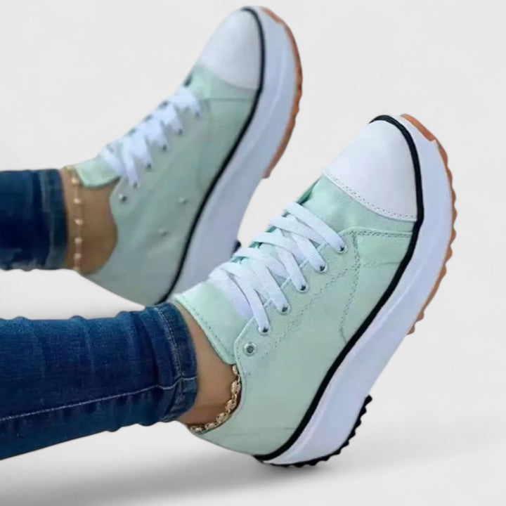 A woman in bold lace-up platform comfort trainers styled with jeans.