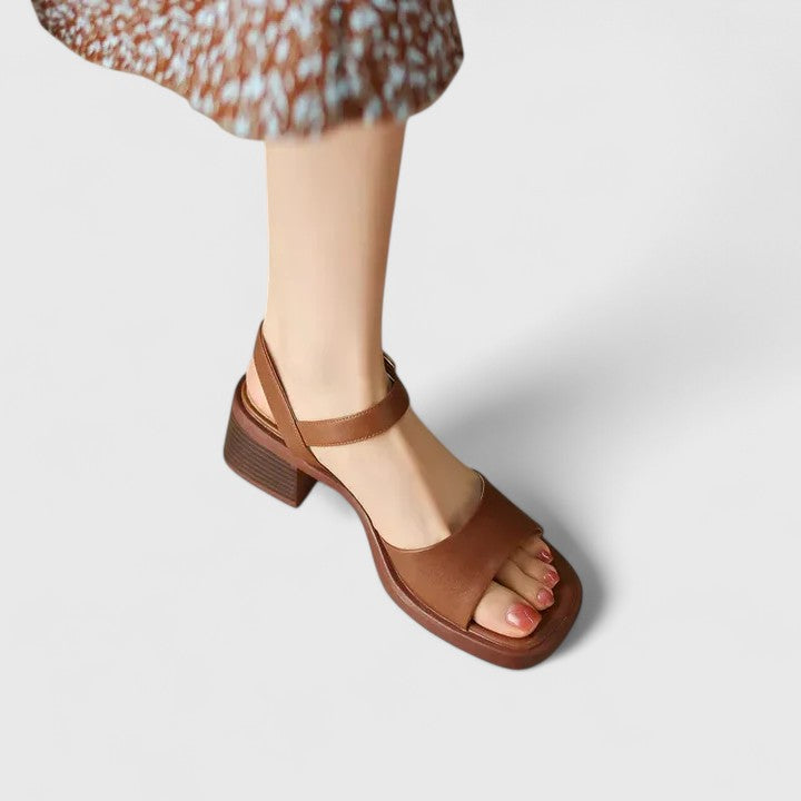 A woman in brown block heel sandals with an ankle strap, dressed for the day.