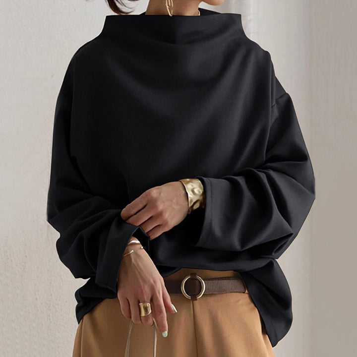 A woman wearing a soft funnel neck jumper styled with jeans for a relaxed elegant look.
