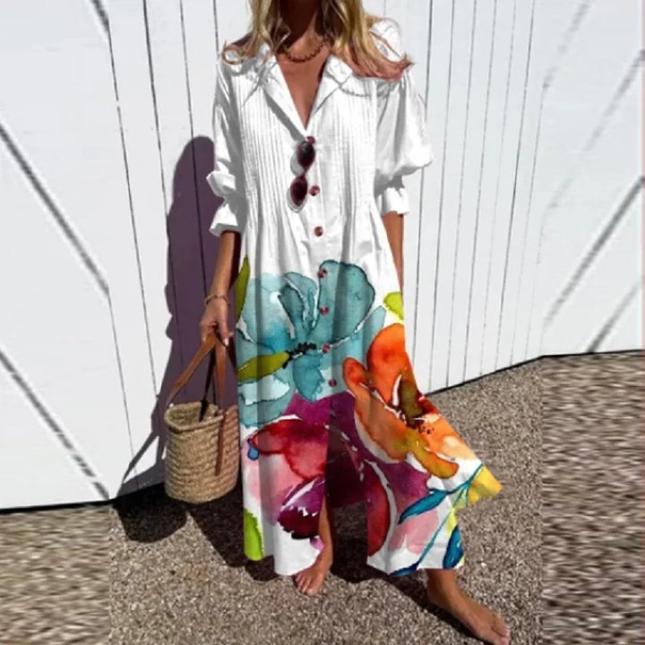Woman wearing the Zara™ leaf print maxi dress with a button front, walking along the coast in a light breeze.