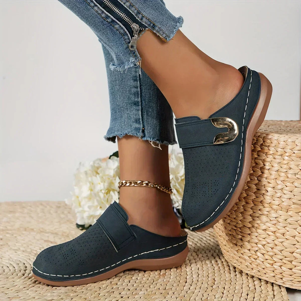 Black closed-toe clogs with decorative buckle detail
