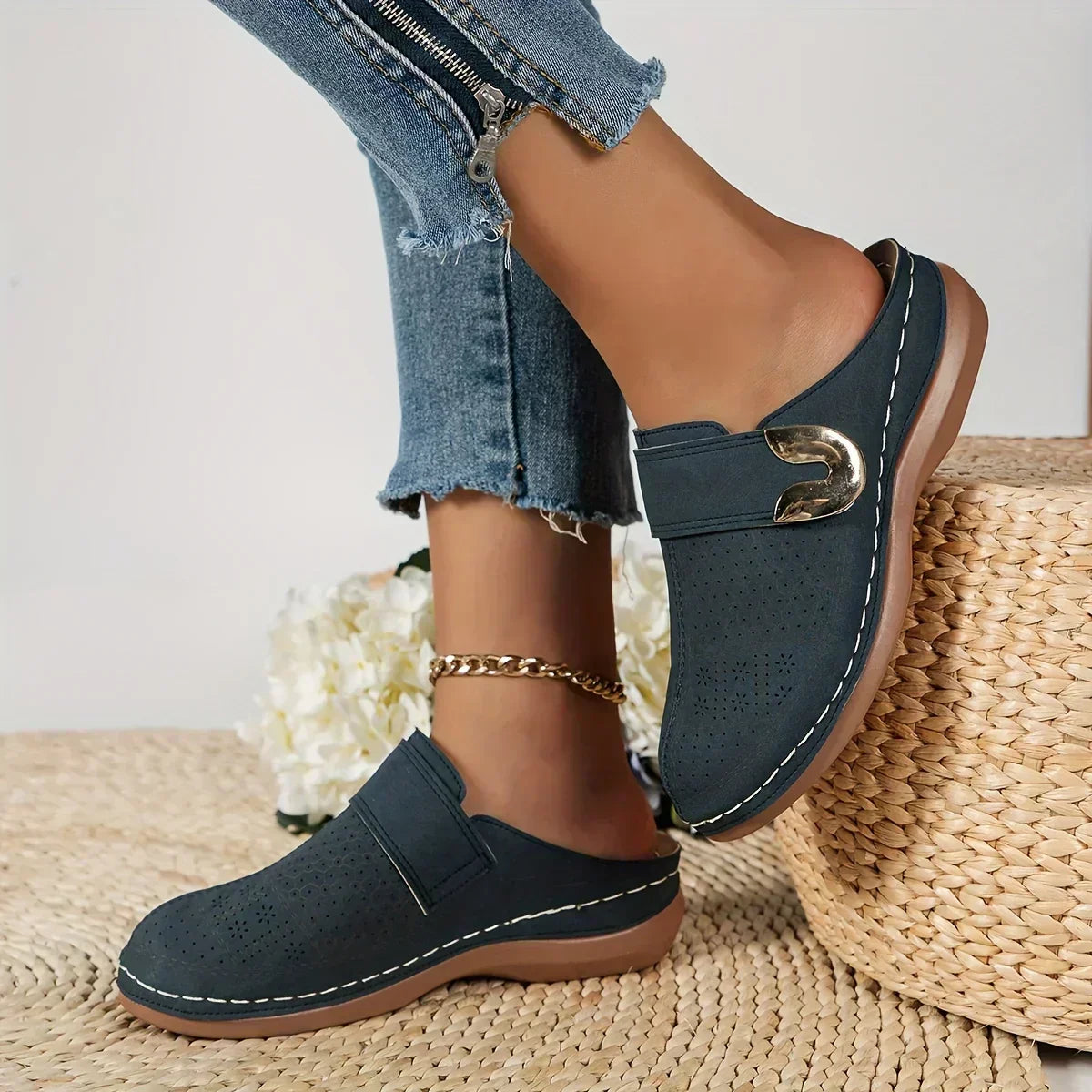 Black closed-toe clogs with decorative buckle detail