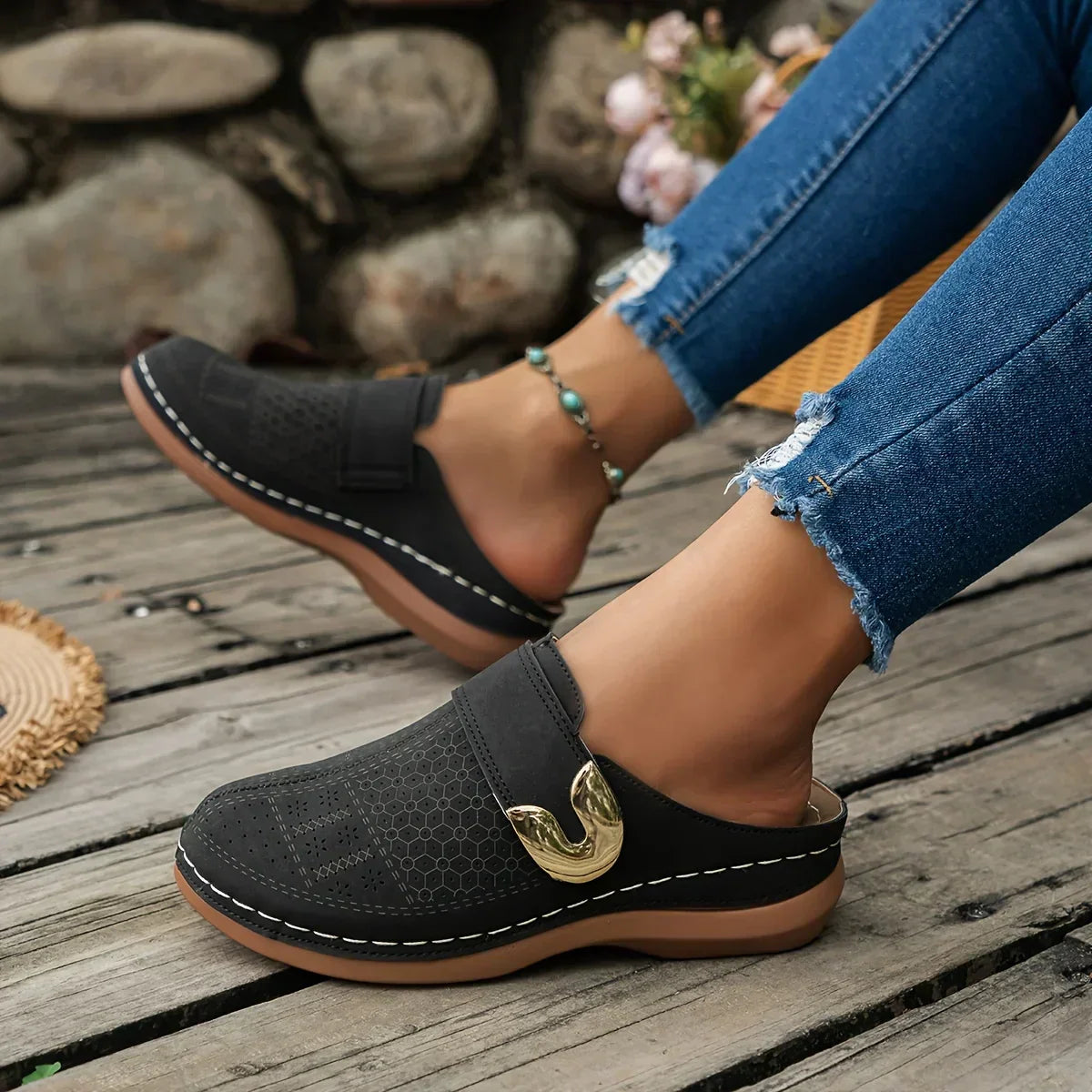 Black closed-toe clogs with decorative buckle detail