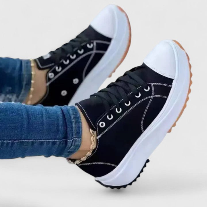 A woman in bold lace-up platform comfort trainers styled with jeans.