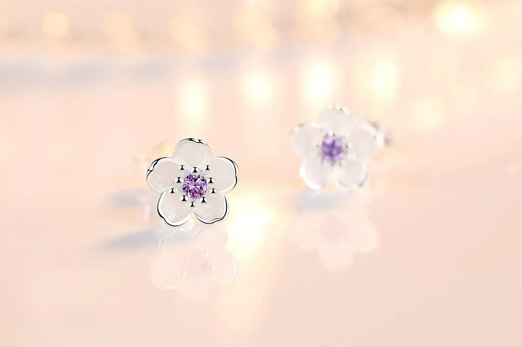 A pair of fine floral stud earrings in polished silver set with pink and purple zirconia stones